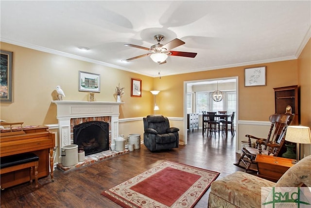 living room with a fireplace, a ceiling fan, wood finished floors, and ornamental molding