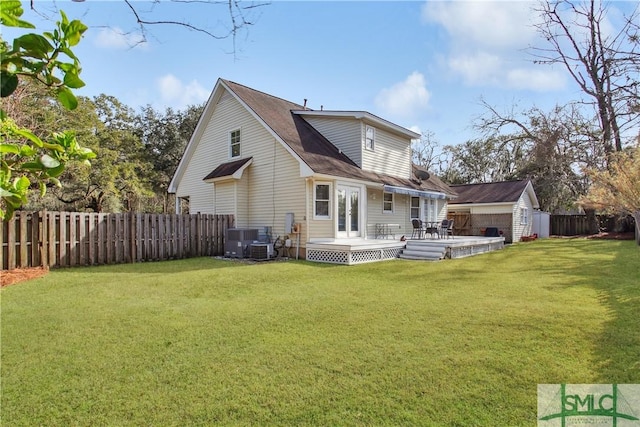 back of property featuring an outbuilding, cooling unit, a wooden deck, a yard, and a fenced backyard