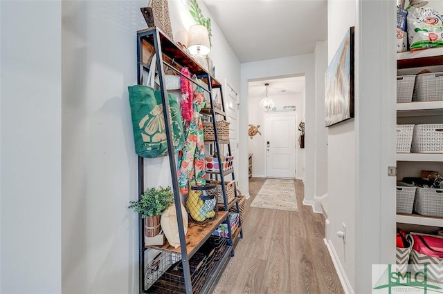 hallway featuring baseboards and wood finished floors