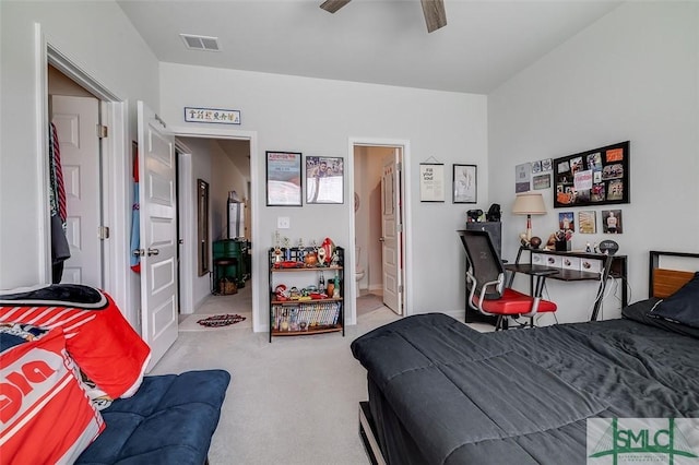 bedroom with carpet floors, visible vents, ceiling fan, and ensuite bath