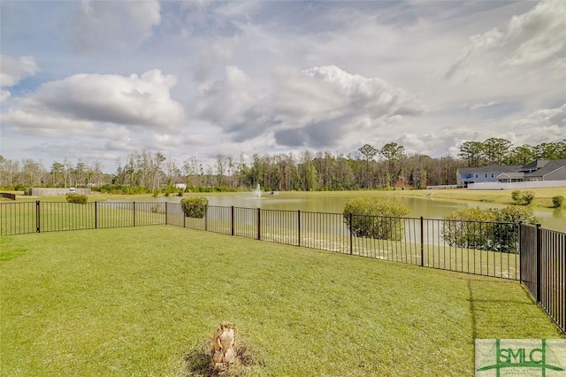 view of yard with a water view and fence