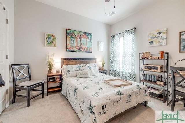 bedroom with ceiling fan, visible vents, and light colored carpet