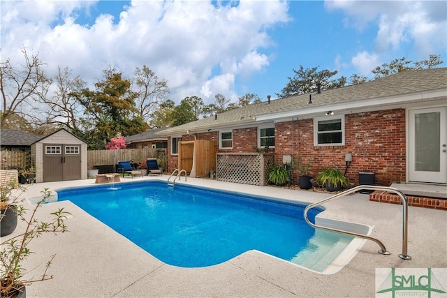 view of swimming pool with an outbuilding, a fenced in pool, fence, a storage unit, and a patio
