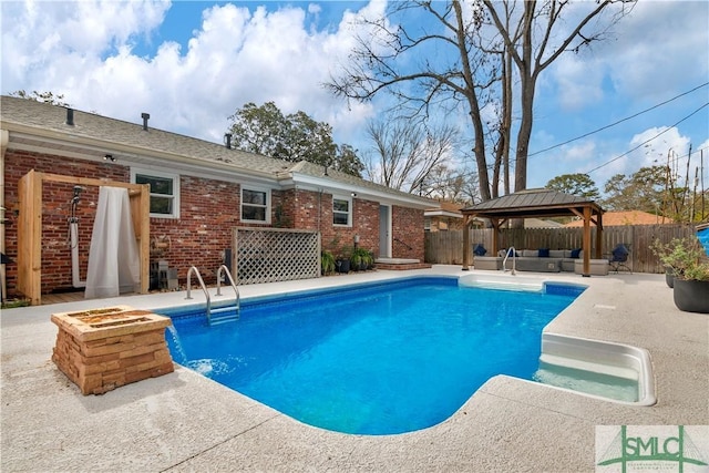 view of swimming pool with a fenced in pool, outdoor lounge area, a fenced backyard, and a gazebo