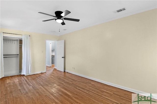 unfurnished bedroom with a ceiling fan, visible vents, light wood-type flooring, baseboards, and a closet