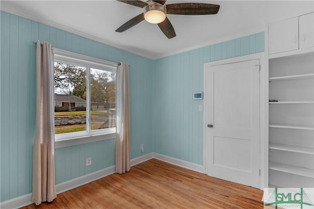 empty room featuring light wood-type flooring, baseboards, and ceiling fan