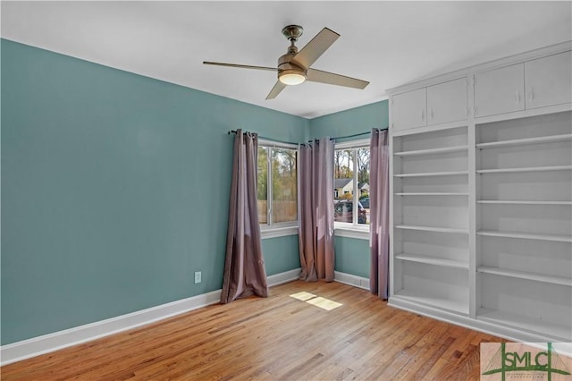 unfurnished room with baseboards, ceiling fan, and light wood finished floors