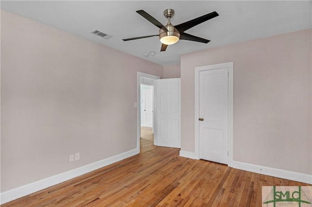 unfurnished bedroom featuring visible vents, a ceiling fan, baseboards, and wood finished floors