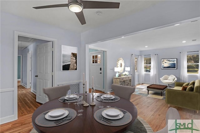 dining area with baseboards, a ceiling fan, attic access, and wood finished floors