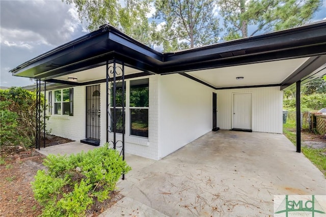 view of front of house featuring driveway, an attached carport, and brick siding