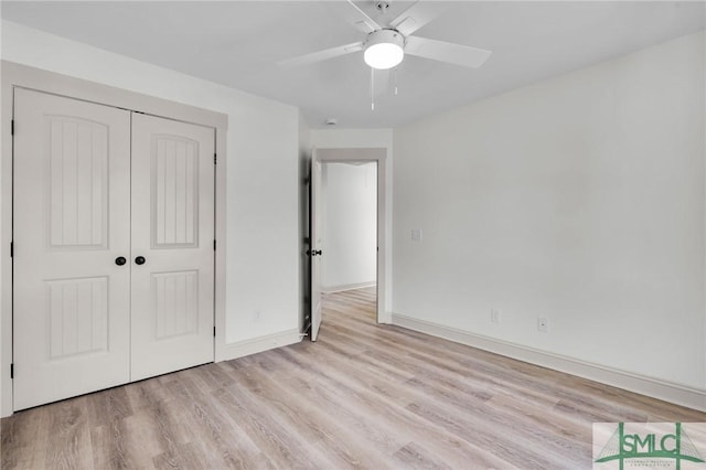 unfurnished bedroom featuring light wood-type flooring, ceiling fan, baseboards, and a closet