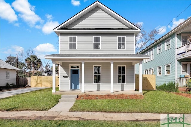 view of front of house featuring covered porch, fence, and a front yard