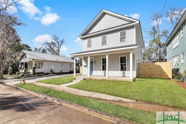 view of front of home featuring a front yard, covered porch, and fence