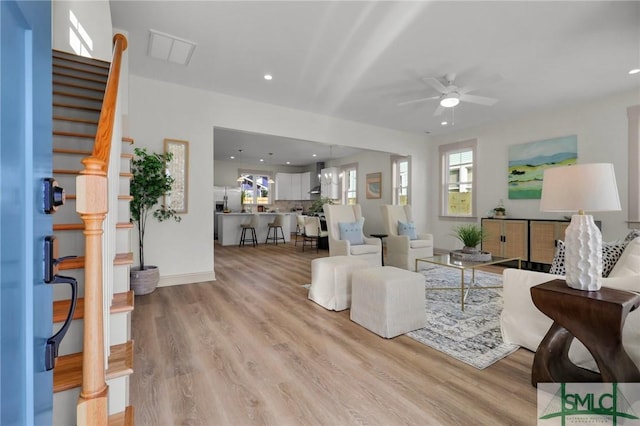 living room with visible vents, ceiling fan, stairway, light wood-type flooring, and recessed lighting