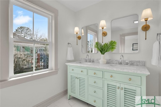 bathroom with marble finish floor, a sink, baseboards, and double vanity