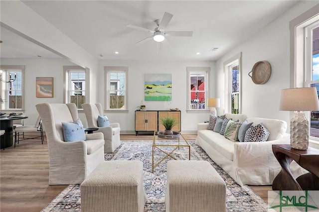 living room with light wood finished floors, visible vents, and recessed lighting