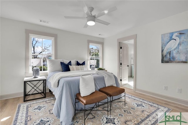 bedroom with light wood-style flooring, visible vents, and baseboards