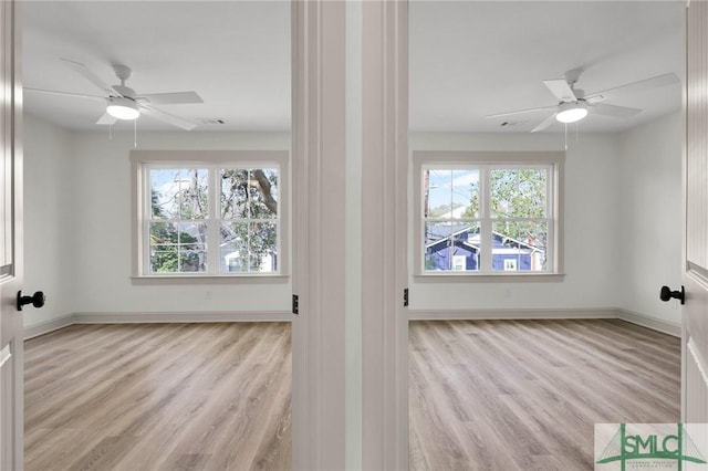 spare room with plenty of natural light, wood finished floors, and visible vents