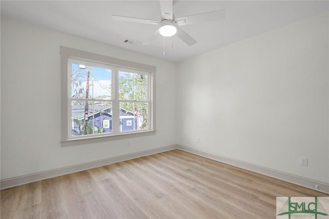 spare room featuring light wood-style floors, visible vents, baseboards, and a ceiling fan