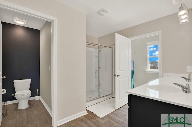 bathroom with toilet, wood finished floors, a shower stall, and visible vents