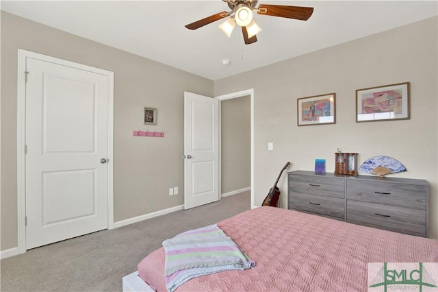 carpeted bedroom with ceiling fan and baseboards