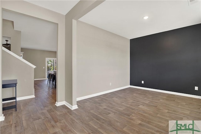 unfurnished room with baseboards, wood finished floors, and recessed lighting