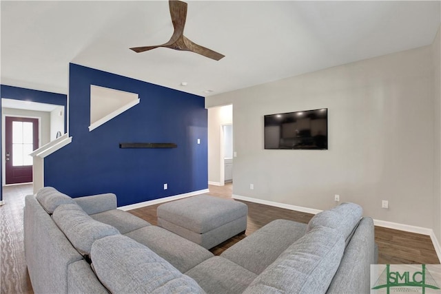 living area with ceiling fan, wood finished floors, and baseboards