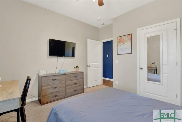 bedroom featuring light colored carpet, ceiling fan, visible vents, and baseboards