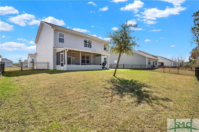 back of property with a yard, a fenced backyard, and a sunroom