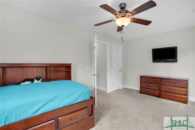 carpeted bedroom with ceiling fan and baseboards