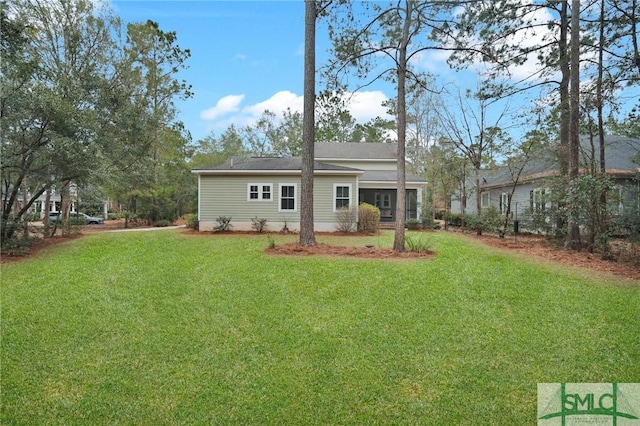 back of house with a lawn