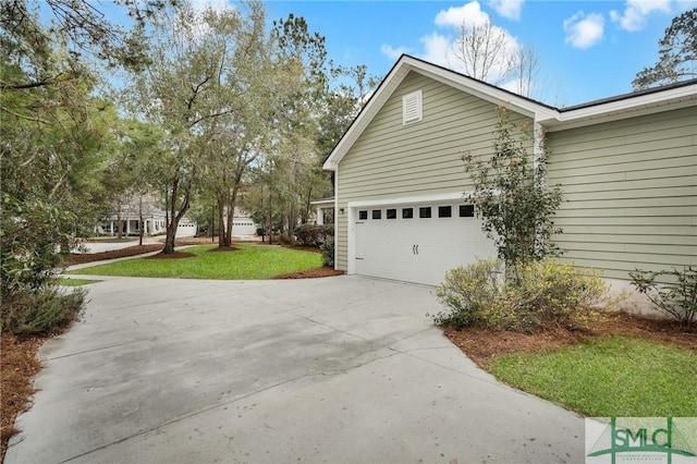 view of home's exterior with concrete driveway and a lawn