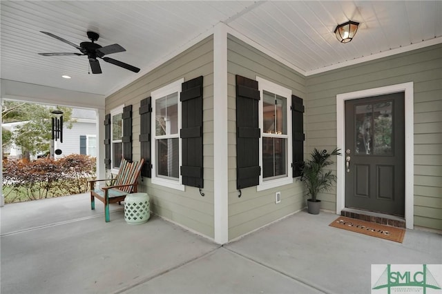 view of exterior entry with a porch and ceiling fan