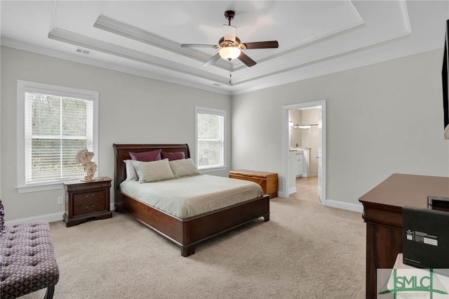 bedroom featuring light carpet, baseboards, multiple windows, and a tray ceiling