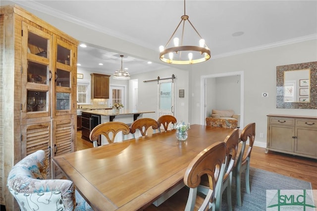 dining room with a barn door, baseboards, ornamental molding, wood finished floors, and recessed lighting