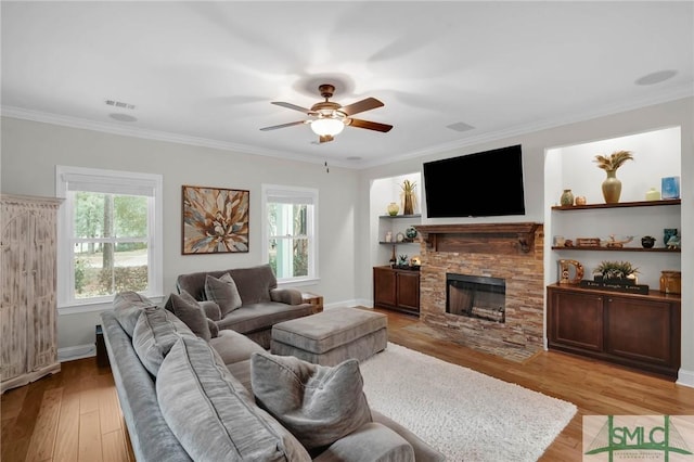 living room featuring light wood-style floors, visible vents, and crown molding