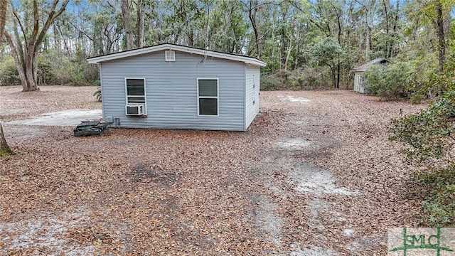 view of outdoor structure with cooling unit, an outdoor structure, and a view of trees