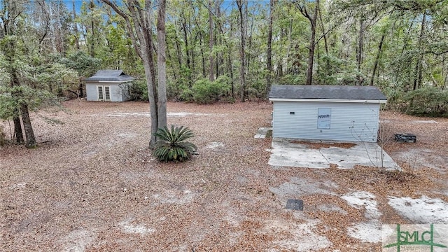 view of yard featuring an outbuilding and a forest view