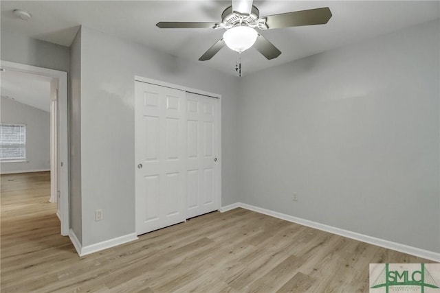 unfurnished bedroom with light wood-style flooring, baseboards, ceiling fan, and a closet