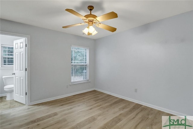 unfurnished bedroom with ceiling fan, light wood-type flooring, connected bathroom, and baseboards