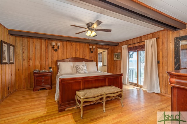 bedroom with wooden walls, light wood finished floors, and access to exterior