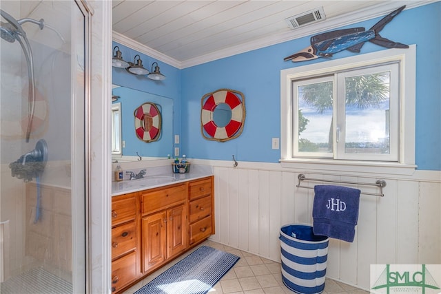 full bathroom with a stall shower, wainscoting, vanity, and visible vents