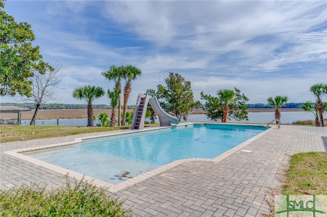 view of swimming pool with a fenced in pool, a water slide, a water view, and a patio