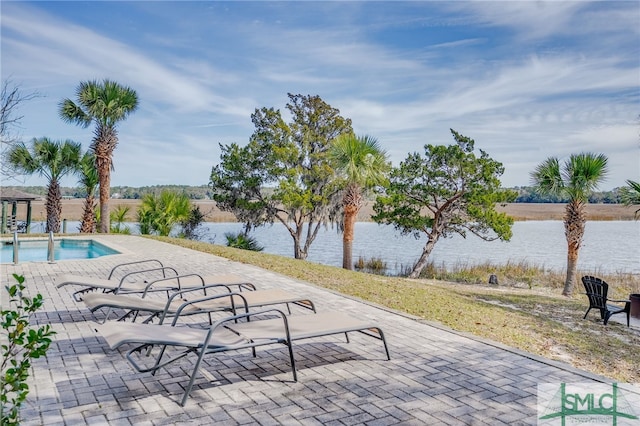 view of property's community featuring a water view, a patio, and a swimming pool