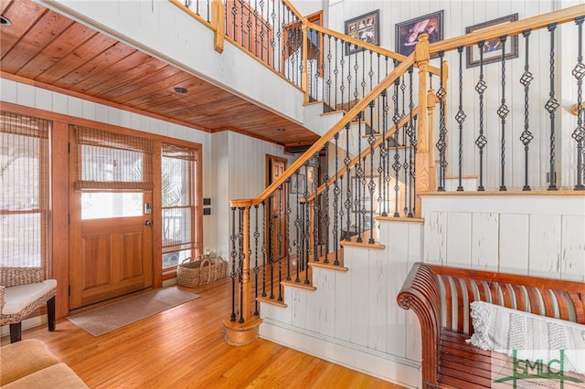 foyer with wooden ceiling, stairway, and wood finished floors