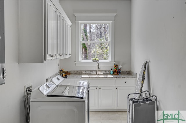 laundry room with cabinet space, washing machine and dryer, light tile patterned floors, and a sink