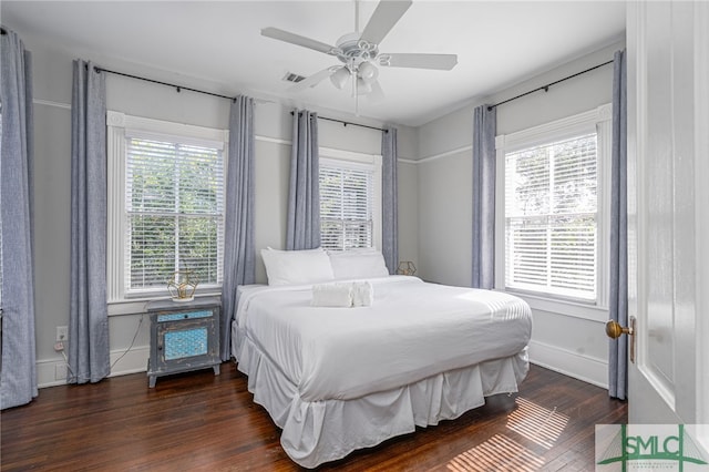 bedroom with baseboards, multiple windows, visible vents, and dark wood-style flooring