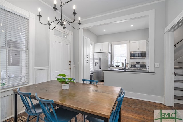 dining room featuring a notable chandelier, stairway, dark wood-type flooring, and wainscoting