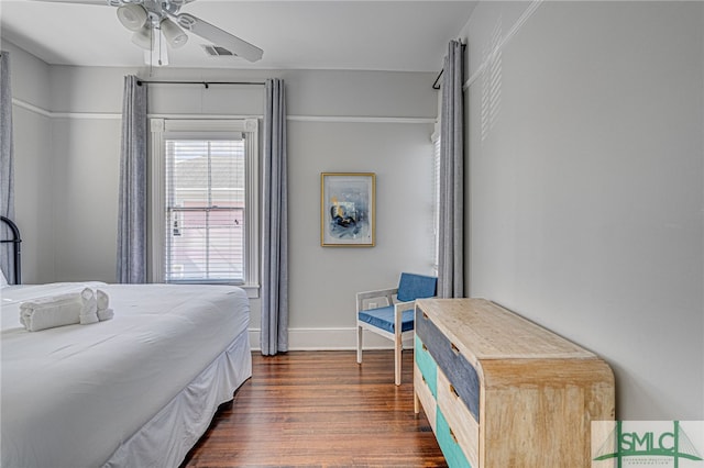 bedroom with dark wood-style floors, visible vents, ceiling fan, and baseboards