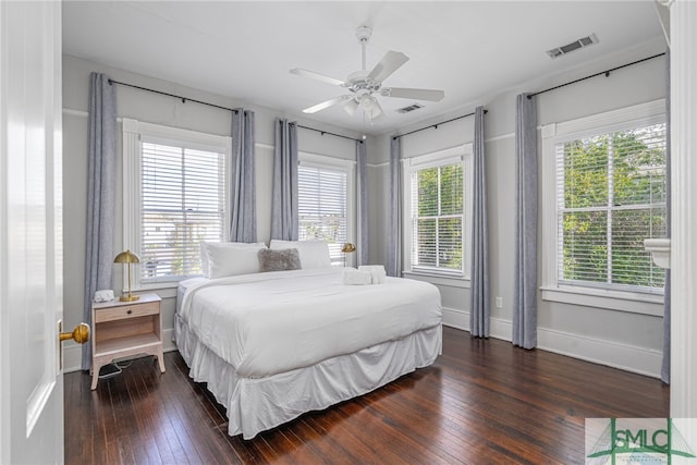 bedroom featuring dark wood-style floors, multiple windows, and visible vents